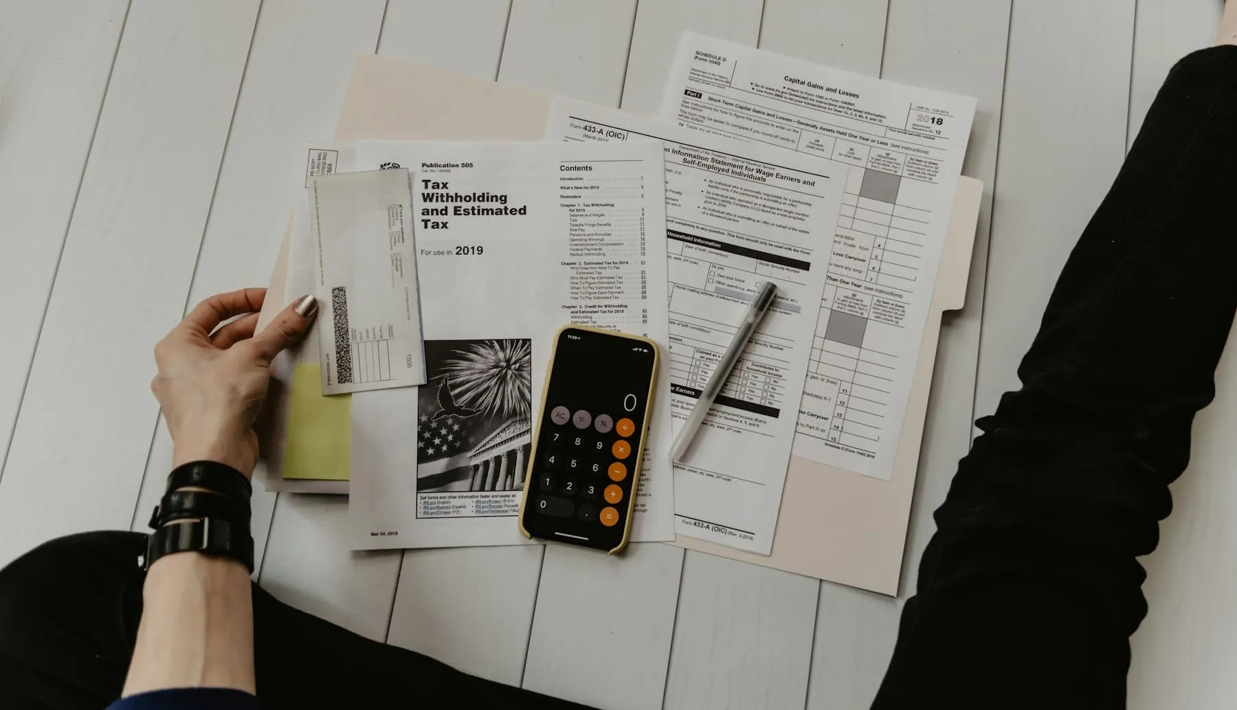 Calculator, ledger, and financial papers on a desk