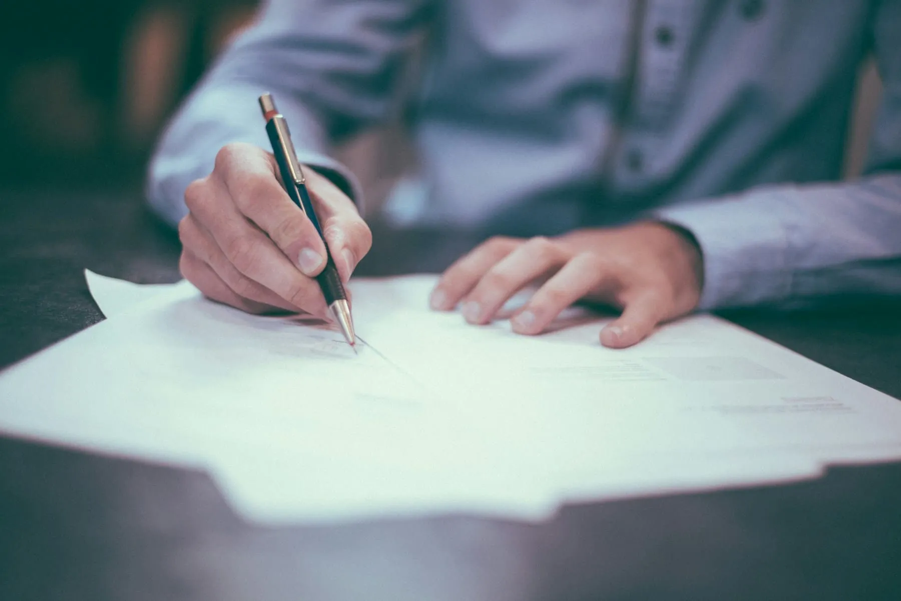 A buyer signing mortgage paperwork at a desk
